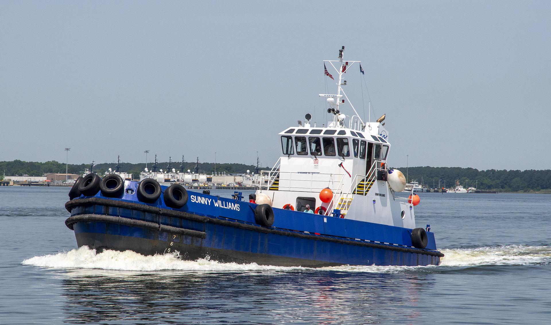 Blue and white workboat under way in a harbour, the type of vessel CetaNav tracks